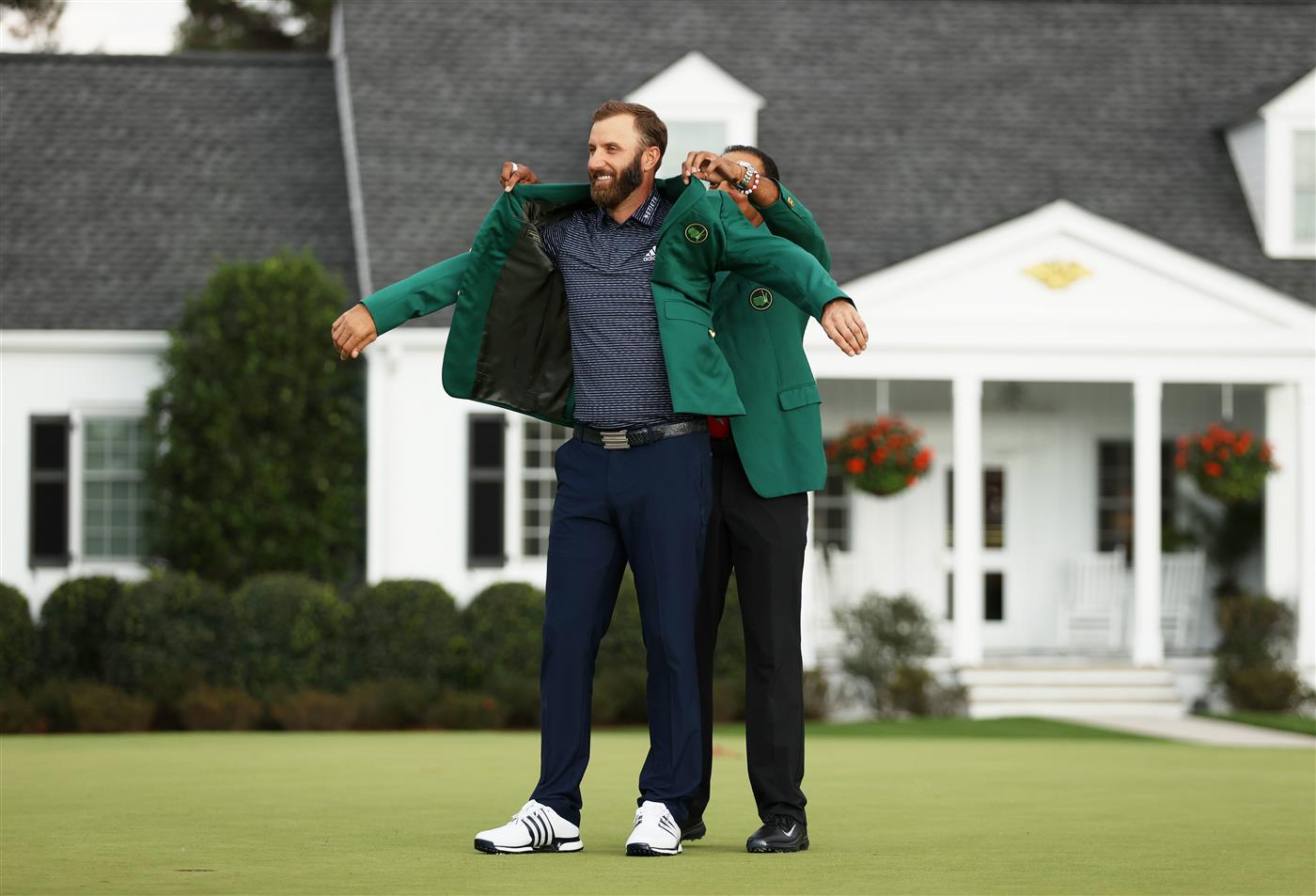 Dustin Johnson is awarded the Green Jacket by Masters champion Tiger Woods during the Green Jacket Ceremony after winning the Masters at Augusta National Golf Club (Photo by Getty Images)