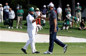 Dustin Johnson reacts with Dale Vallely, caddie for Abraham Ancer of Mexico (not pictured), on the 18th green after winning the Masters at Augusta National Golf Club (Photo by Getty Images)