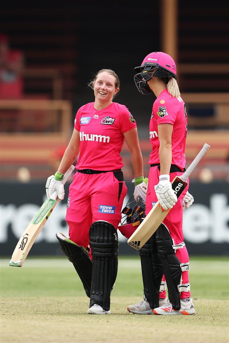 SYDNEY, AUSTRALIA - NOVEMBER 22: Alyssa Healy of the Sixers celebrates scoring a century with team mate Ellyse Perry of the Sixers during the Women's Big Bash League WBBL match between the Melbourne Stars and the Sydney Sixers at North Sydney Oval, on November 22, 2020, in Sydney, Australia. (Photo by Cameron Spencer/Getty Images)