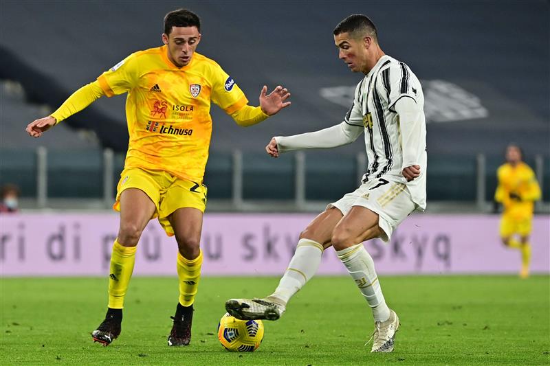 Portuguese forward Cristiano Ronaldo challenges Cagliari's Italian defender Gabriele Zappa (L) during the Italian Serie A football match Juventus vs Cagliari on November 21, 2020 at the Juventus stadium in Turin. (Photo by MIGUEL MEDINA / AFP) (Photo by MIGUEL MEDINA/AFP via Getty Images)