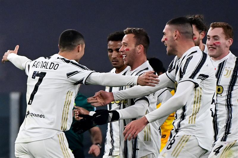 Portuguese forward Cristiano Ronaldo (L) celebrates with Juventus' Brazilian midfielder Arthur (C) and teammates after opening the scoring during the Italian Serie A football match Juventus vs Cagliari on November 21, 2020 at the Juventus stadium in Turin. (Photo by MIGUEL MEDINA / AFP) (Photo by MIGUEL MEDINA/AFP via Getty Images)
