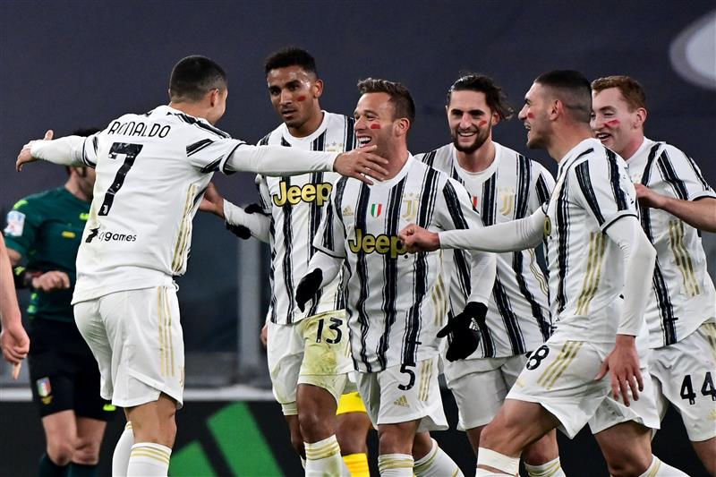 Portuguese forward Cristiano Ronaldo (L) celebrates with Juventus' Brazilian midfielder Arthur (C) and teammates after opening the scoring during the Italian Serie A football match Juventus vs Cagliari on November 21, 2020 at the Juventus stadium in Turin. (Photo by MIGUEL MEDINA / AFP) (Photo by MIGUEL MEDINA/AFP via Getty Images)