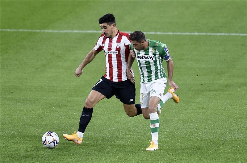 BILBAO, SPAIN - NOVEMBER 23: Yuri Berchiche of Athletic Bilbao  is challenged by Joaquin of Real Betis during the La Liga Santander match between Athletic Club and Real Betis at Estadio de San Mames on November 23, 2020 in Bilbao, Spain. Sporting stadiums around Spain remain under strict restrictions due to the Coronavirus Pandemic as Government social distancing laws prohibit fans inside venues resulting in games being played behind closed doors. (Photo by Juan Manuel Serrano Arce/Getty Images)