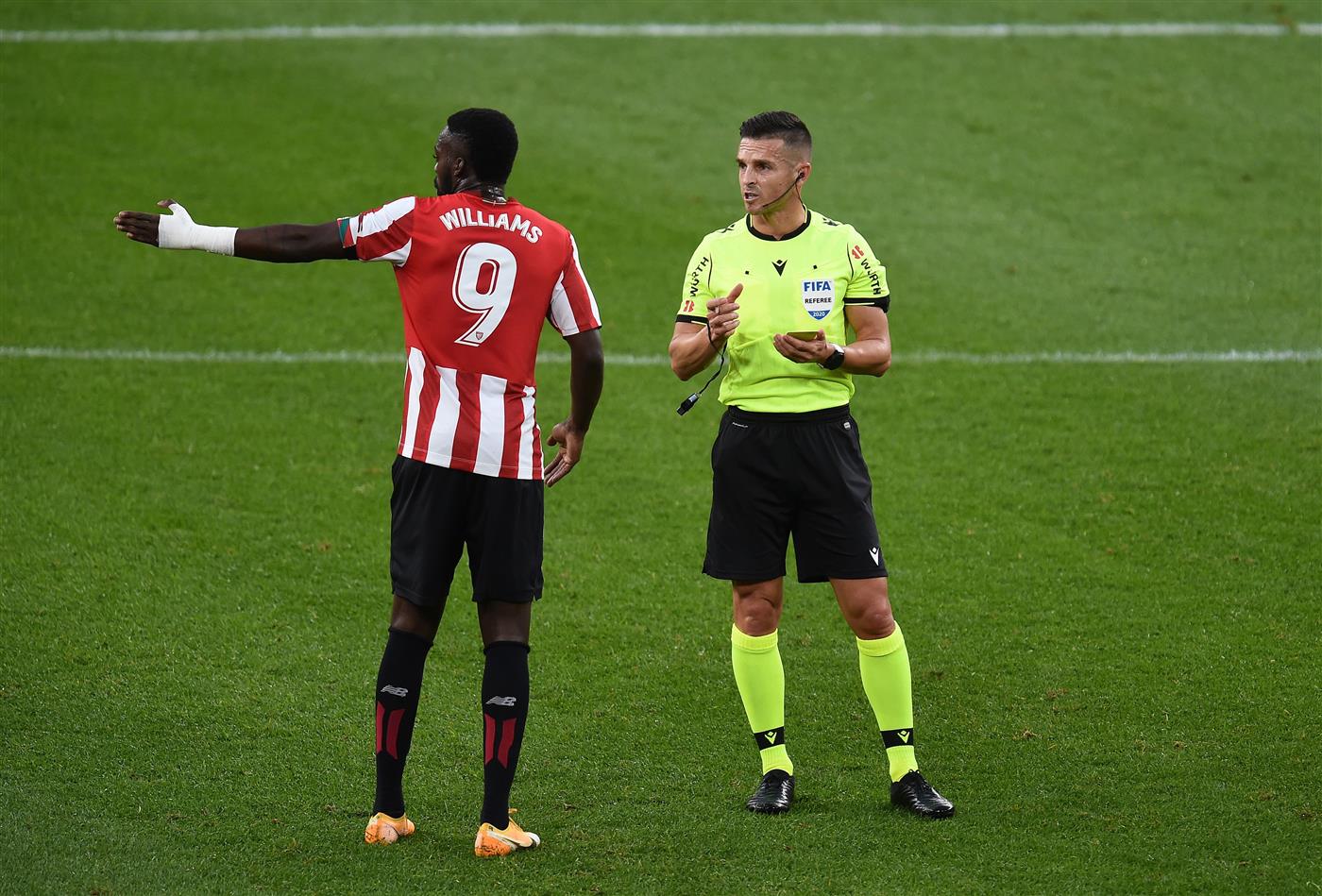 BILBAO, SPAIN - OCTOBER 31: Referee Carlos Del Cerro Grande speaks with Inaki Williams of Athletic Club during the La Liga Santander match between Athletic Club and Sevilla FC at Estadio de San Mames on October 31, 2020 in Bilbao, Spain. Sporting stadiums around Spain remain under strict restrictions due to the Coronavirus Pandemic as Government social distancing laws prohibit fans inside venues resulting in games being played behind closed doors. (Photo by Juan Manuel Serrano Arce/Getty Images)