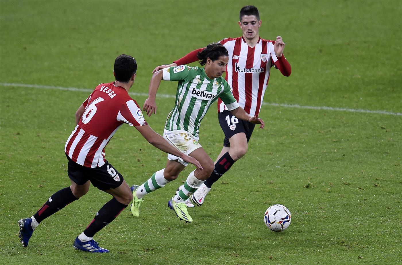 BILBAO, SPAIN - NOVEMBER 23: Diego Lainez of Real Betis is challenged by Oihan Sancet and Mikel Vesga of Athletic Bilbao during the La Liga Santander match between Athletic Club and Real Betis at Estadio de San Mames on November 23, 2020 in Bilbao, Spain. Sporting stadiums around Spain remain under strict restrictions due to the Coronavirus Pandemic as Government social distancing laws prohibit fans inside venues resulting in games being played behind closed doors. (Photo by Juan Manuel Serrano Arce/Getty Images)