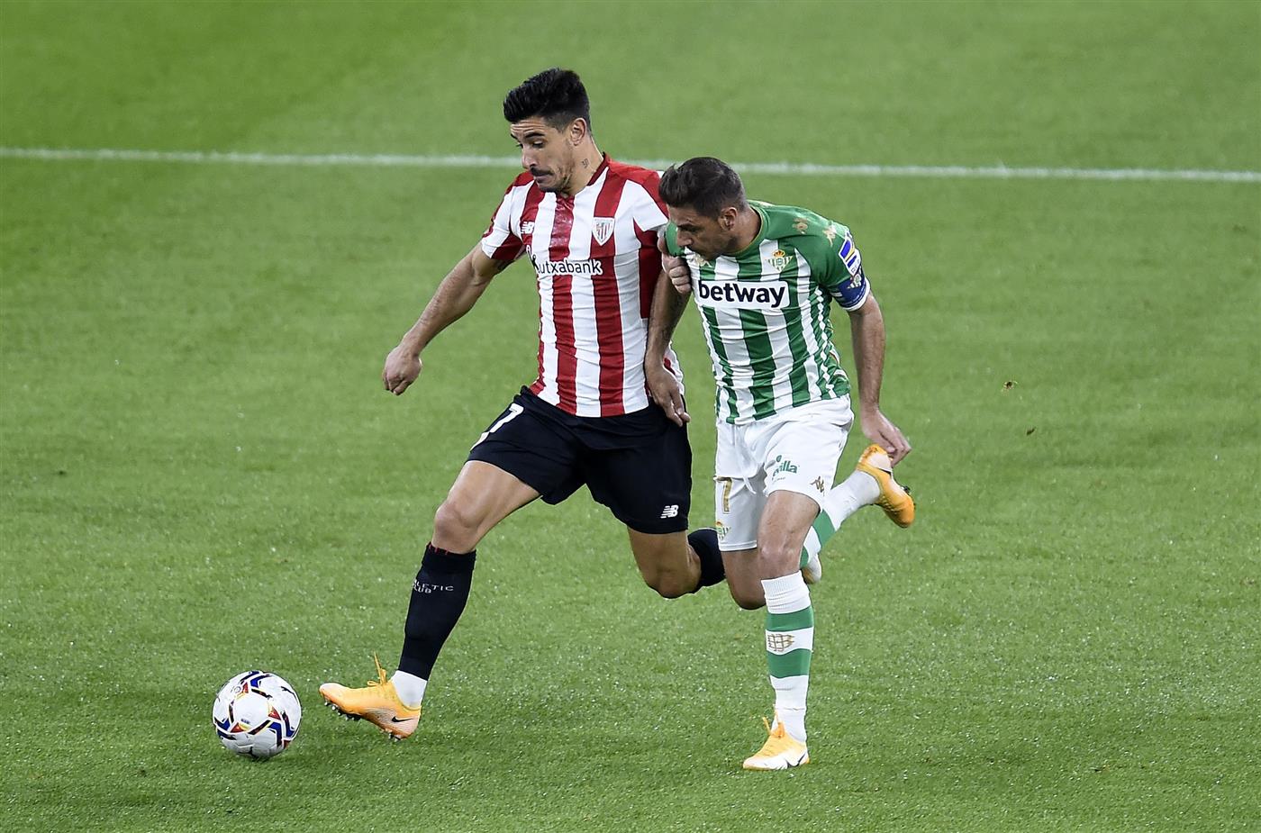 BILBAO, SPAIN - NOVEMBER 23: Yuri Berchiche of Athletic Bilbao  is challenged by Joaquin of Real Betis during the La Liga Santander match between Athletic Club and Real Betis at Estadio de San Mames on November 23, 2020 in Bilbao, Spain. Sporting stadiums around Spain remain under strict restrictions due to the Coronavirus Pandemic as Government social distancing laws prohibit fans inside venues resulting in games being played behind closed doors. (Photo by Juan Manuel Serrano Arce/Getty Images)