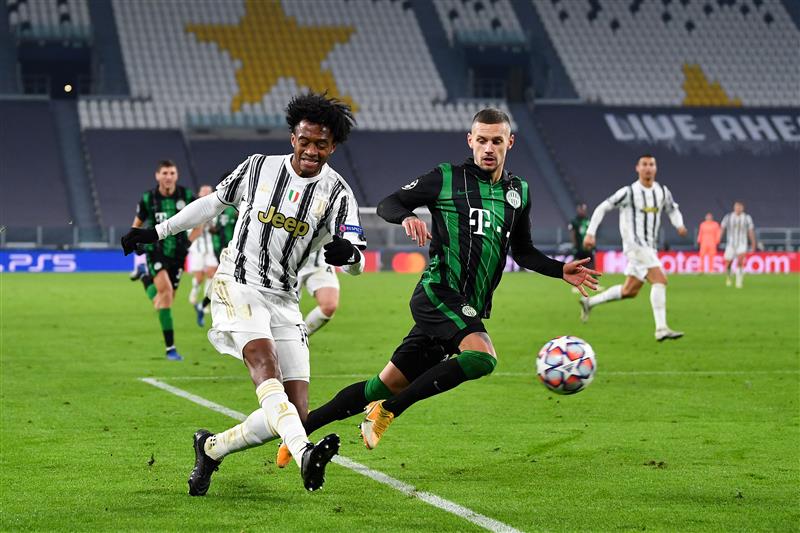 TURIN, ITALY - NOVEMBER 24: Juan Cuadrado of Juventus F.C. and Marcel Heister of Ferencvaros battle for the ball during the UEFA Champions League Group G stage match between Juventus and Ferencvaros Budapest at Allianz Stadium on November 24, 2020 in Turin, Italy. Sporting stadiums around Italy remain under strict restrictions due to the Coronavirus Pandemic as Government social distancing laws prohibit fans inside venues resulting in games being played behind closed doors. (Photo by Valerio Pennicino/Getty Images)