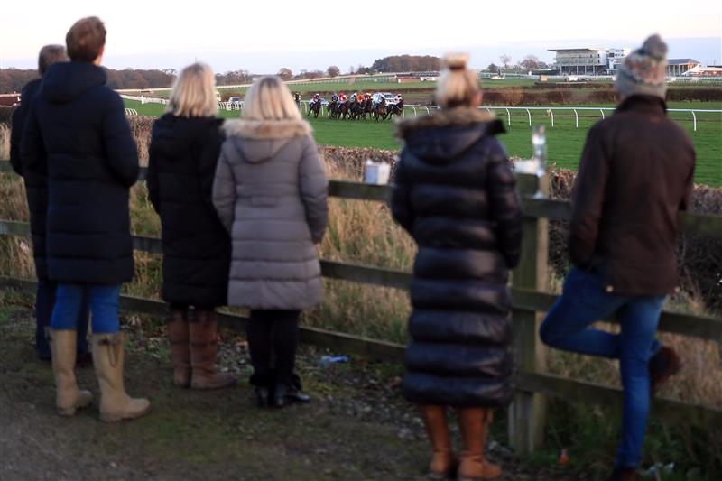 WETHERBY, UNITED KINGDOM - NOVEMBER 25: Spectators outside the course grounds watch the runners and riders in the EBF Stallions Mares' Standard Open National Hunt Flat Race (GBB Race) at Wetherby Racecourse on November 25, 2020 in Wetherby, England. (Photo by Mike Egerton - Pool/Getty Images)