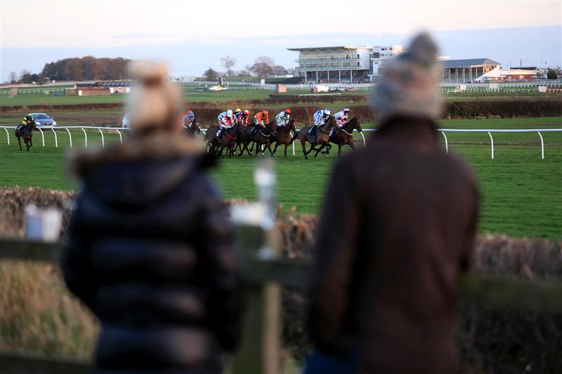 WETHERBY, UNITED KINGDOM - NOVEMBER 25: Spectators outside the course grounds watch the runners and riders in the EBF Stallions Mares' Standard Open National Hunt Flat Race (GBB Race) at Wetherby Racecourse on November 25, 2020 in Wetherby, England. (Photo by Mike Egerton - Pool/Getty Images)