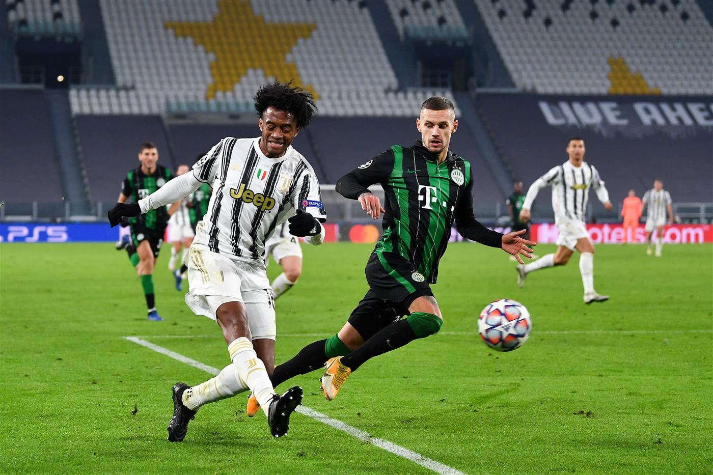 TURIN, ITALY - NOVEMBER 24: Juan Cuadrado of Juventus F.C. and Marcel Heister of Ferencvaros battle for the ball during the UEFA Champions League Group G stage match between Juventus and Ferencvaros Budapest at Allianz Stadium on November 24, 2020 in Turin, Italy. Sporting stadiums around Italy remain under strict restrictions due to the Coronavirus Pandemic as Government social distancing laws prohibit fans inside venues resulting in games being played behind closed doors. (Photo by Valerio Pennicino/Getty Images)