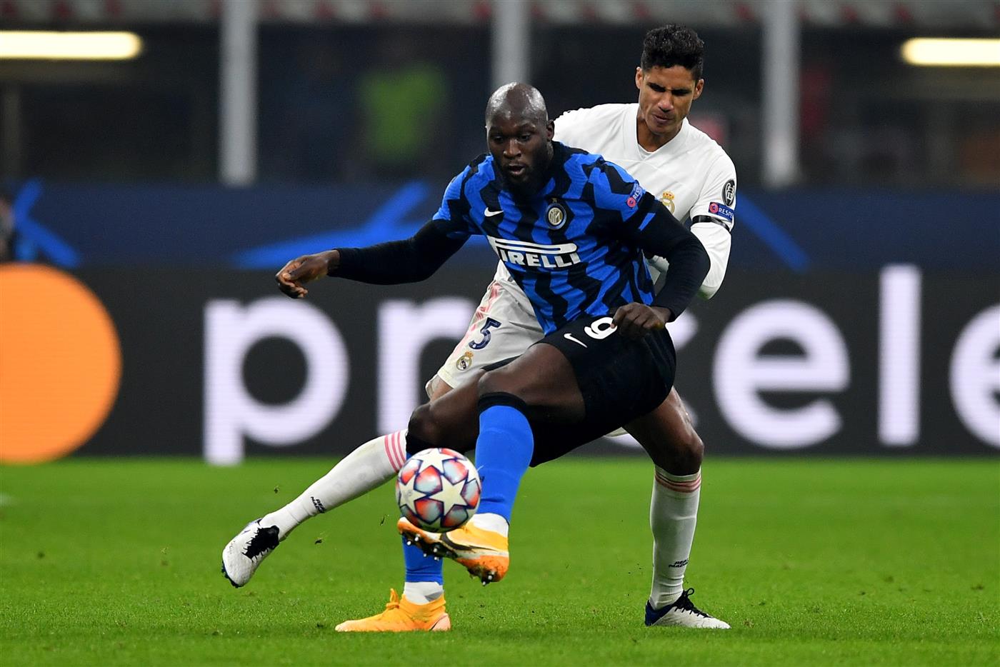 MILAN, ITALY - NOVEMBER 25: Romelu Lukaku of Inter Milan is challenged by Raphael Varane of Real Madrid during the UEFA Champions League Group B stage match between FC Internazionale and Real Madrid at Stadio Giuseppe Meazza on November 25, 2020 in Milan, Italy. Football Stadiums around Europe remain empty due to the Coronavirus Pandemic as Government social distancing laws prohibit fans inside venues resulting in fixtures being played behind closed doors. (Photo by Valerio Pennicino/Getty Images)