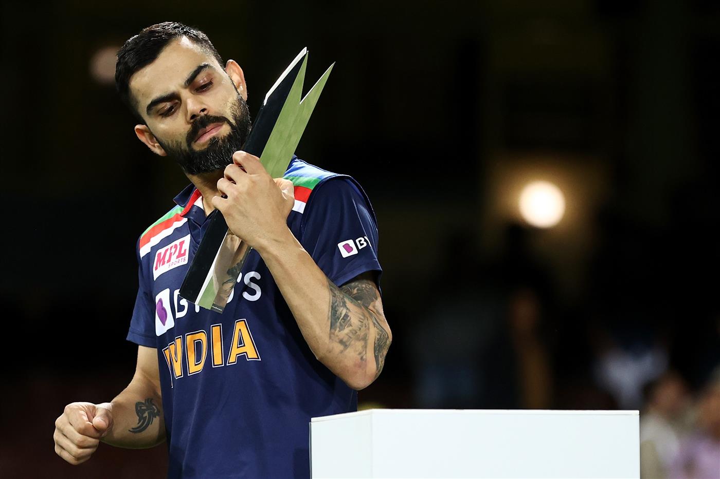 SYDNEY, AUSTRALIA - DECEMBER 08: Virat Kohli of India collects the T20 Trophy following game three of the Twenty20 International series between Australia and India at Sydney Cricket Ground on December 08, 2020 in Sydney, Australia. (Photo by Cameron Spencer/Getty Images)