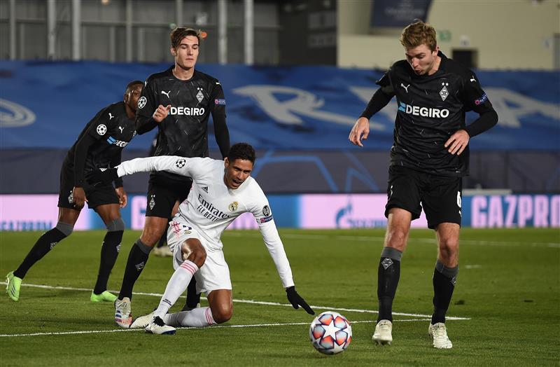 MADRID, SPAIN - DECEMBER 09:  Raphael Varane of Real Madrid loses the ball to Christoph Kramer of Borussia Moenchengladbach reacts during the UEFA Champions League Group B stage match between Real Madrid and Borussia Moenchengladbach at Estadio Alfredo di Stefano on December 09, 2020 in Madrid, Spain. Sporting stadiums around Spain remain under strict restrictions due to the Coronavirus Pandemic as Government social distancing laws prohibit fans inside venues resulting in games being played behind closed doors. (Photo by Denis Doyle/Getty Images)