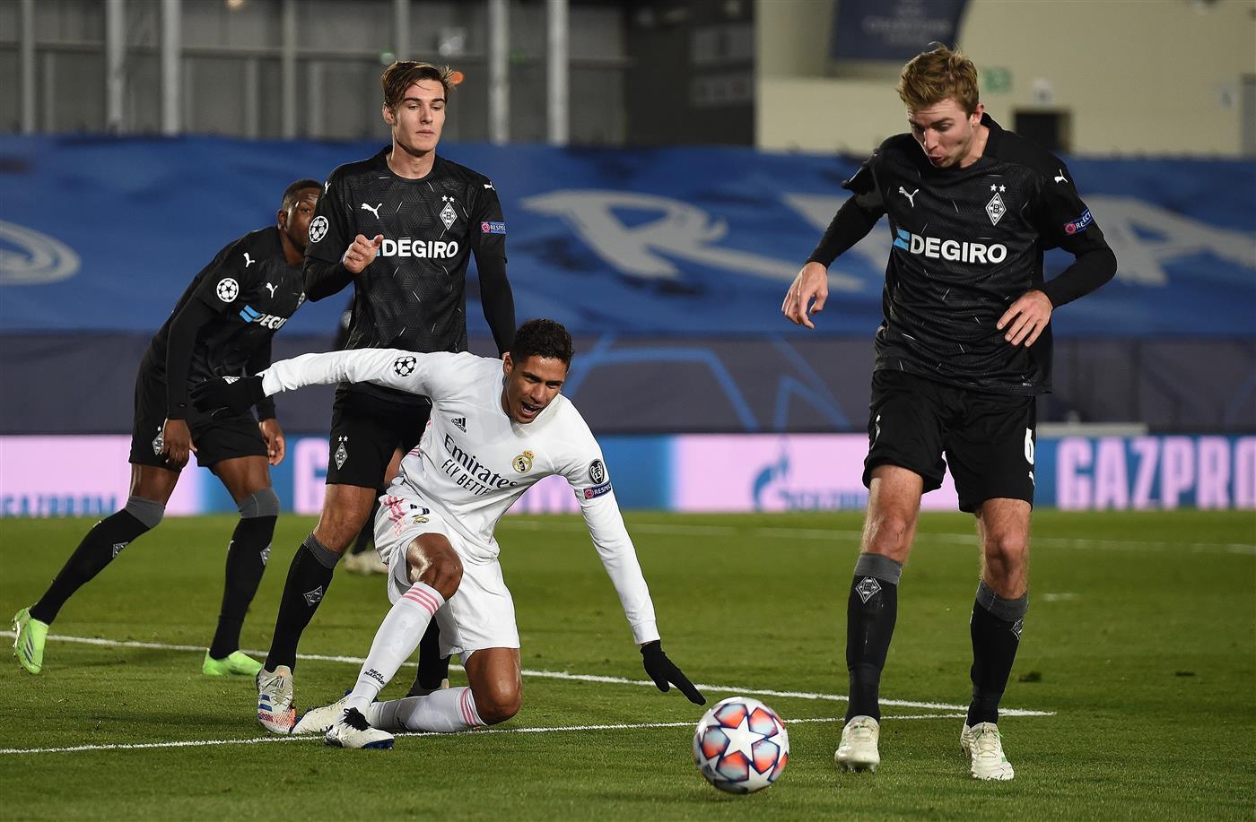 MADRID, SPAIN - DECEMBER 09:  Raphael Varane of Real Madrid loses the ball to Christoph Kramer of Borussia Moenchengladbach reacts during the UEFA Champions League Group B stage match between Real Madrid and Borussia Moenchengladbach at Estadio Alfredo di Stefano on December 09, 2020 in Madrid, Spain. Sporting stadiums around Spain remain under strict restrictions due to the Coronavirus Pandemic as Government social distancing laws prohibit fans inside venues resulting in games being played behind closed doors. (Photo by Denis Doyle/Getty Images)
