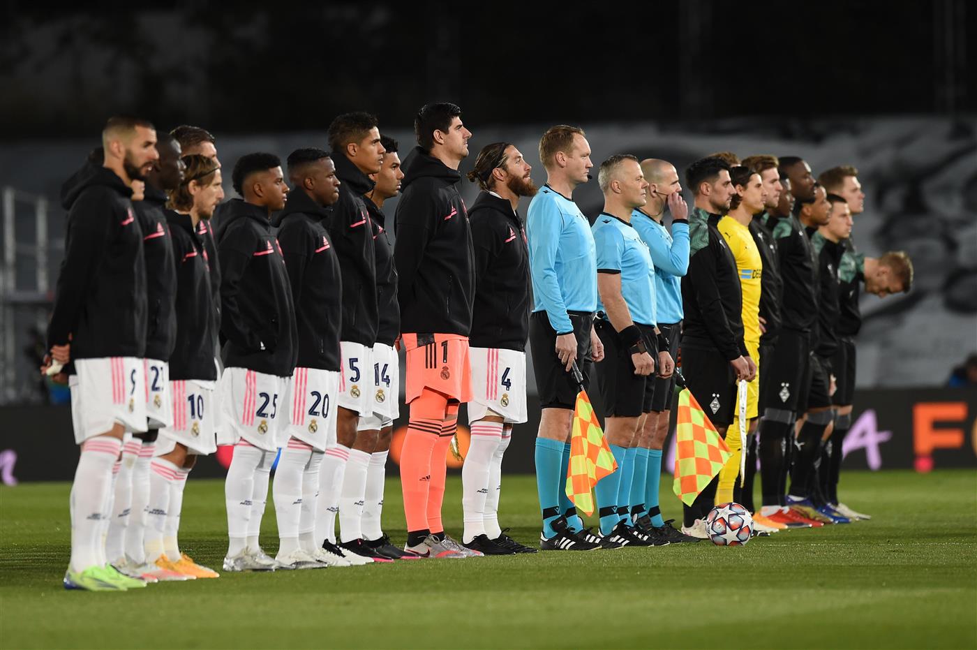 MADRID, SPAIN - DECEMBER 09: Players from both sides and officials line up ahead of the UEFA Champions League Group B stage match between Real Madrid and Borussia Moenchengladbach at Estadio Alfredo di Stefano on December 09, 2020 in Madrid, Spain. Sporting stadiums around Spain remain under strict restrictions due to the Coronavirus Pandemic as Government social distancing laws prohibit fans inside venues resulting in games being played behind closed doors. (Photo by Denis Doyle/Getty Images)
