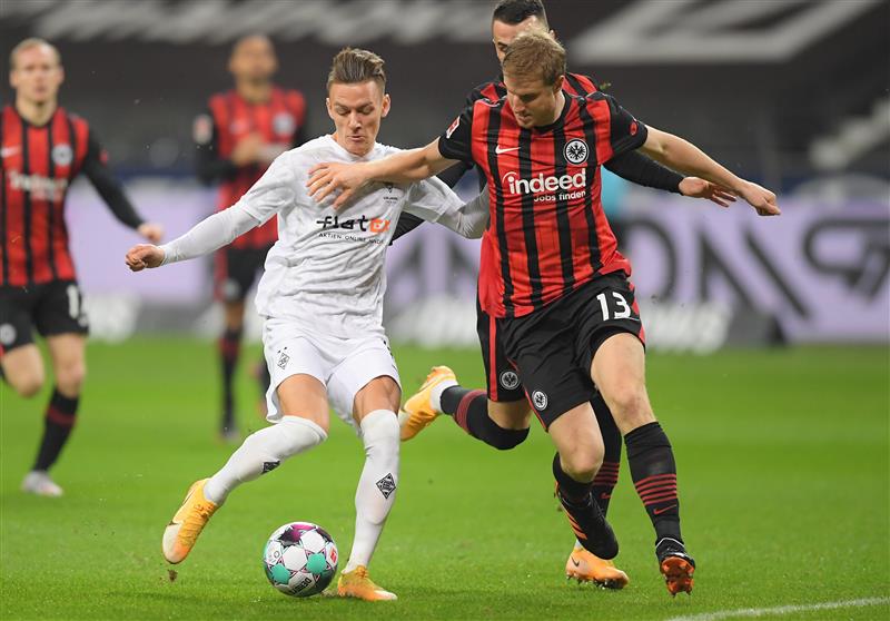 FRANKFURT AM MAIN, GERMANY - DECEMBER 15: Hannes Wolf of Borussia Monchengladbach is challenged by Martin Hinteregger of Eintracht Frankfurt during the Bundesliga match between Eintracht Frankfurt and Borussia Moenchengladbach at Deutsche Bank Park on December 15, 2020 in Frankfurt am Main, Germany. Sporting stadiums around Germany remain under strict restrictions due to the Coronavirus Pandemic as Government social distancing laws prohibit fans inside venues resulting in games being played behind closed doors. (Photo by Alexander Scheuber/Getty Images)
