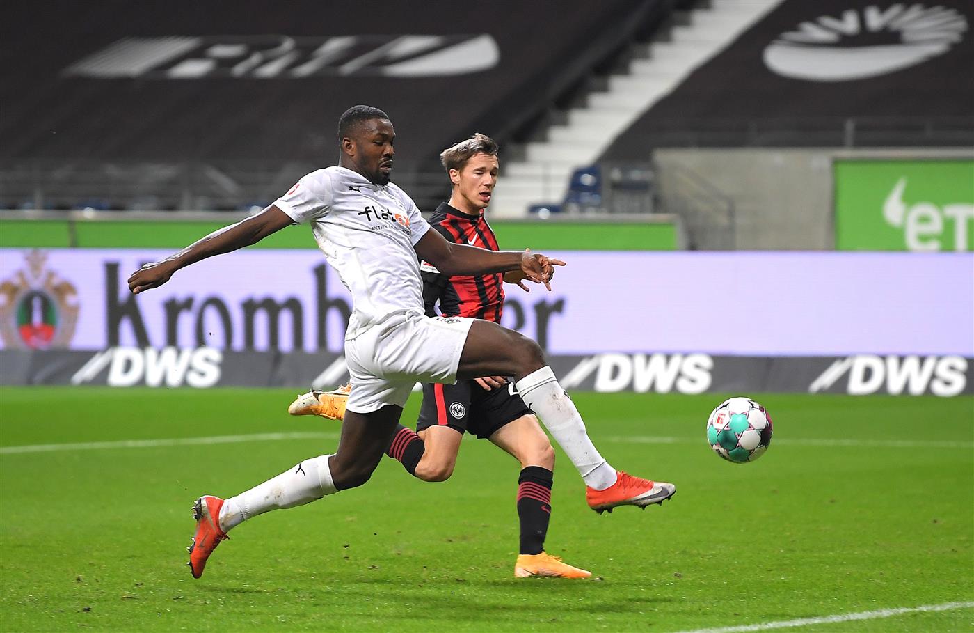 FRANKFURT AM MAIN, GERMANY - DECEMBER 15: Marcus Thuram of Borussia Monchengladbach battle for possession with Erik Durm of Eintracht Frankfurt during the Bundesliga match between Eintracht Frankfurt and Borussia Moenchengladbach at Deutsche Bank Park on December 15, 2020 in Frankfurt am Main, Germany. Sporting stadiums around Germany remain under strict restrictions due to the Coronavirus Pandemic as Government social distancing laws prohibit fans inside venues resulting in games being played behind closed doors. (Photo by Alexander Scheuber/Getty Images)