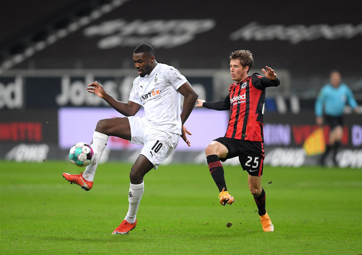FRANKFURT AM MAIN, GERMANY - DECEMBER 15: Marcus Thuram of Borussia Monchengladbach is challenged by Erik Durm of Eintracht Frankfurt during the Bundesliga match between Eintracht Frankfurt and Borussia Moenchengladbach at Deutsche Bank Park on December 15, 2020 in Frankfurt am Main, Germany. Sporting stadiums around Germany remain under strict restrictions due to the Coronavirus Pandemic as Government social distancing laws prohibit fans inside venues resulting in games being played behind closed doors. (Photo by Alexander Scheuber/Getty Images)