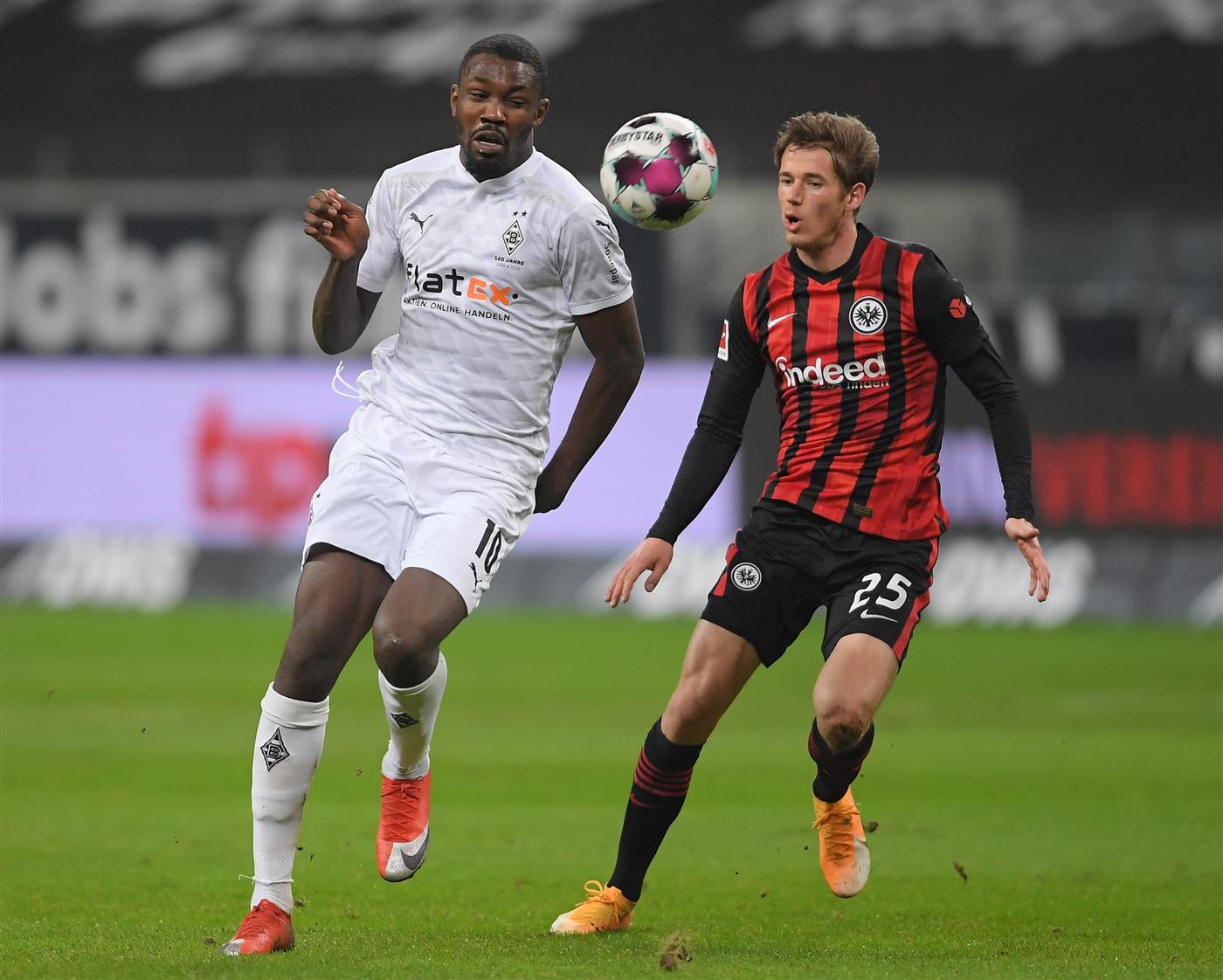 FRANKFURT AM MAIN, GERMANY - DECEMBER 15: Marcus Thuram of Borussia Monchengladbach is challenged by Erik Durm of Eintracht Frankfurt during the Bundesliga match between Eintracht Frankfurt and Borussia Moenchengladbach at Deutsche Bank Park on December 15, 2020 in Frankfurt am Main, Germany. Sporting stadiums around Germany remain under strict restrictions due to the Coronavirus Pandemic as Government social distancing laws prohibit fans inside venues resulting in games being played behind closed doors. (Photo by Alexander Scheuber/Getty Images)
