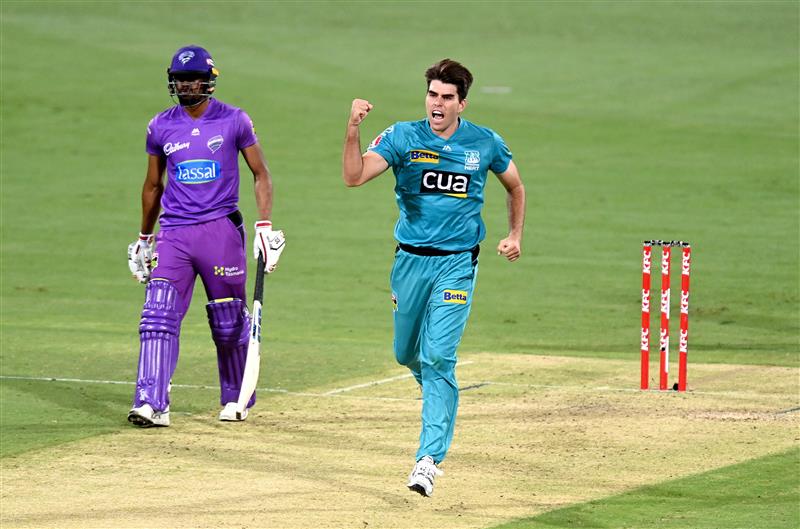 BRISBANE, AUSTRALIA - DECEMBER 30: Xavier Bartlett of the Heat celebrates taking the wicket of Tim David of the Hurricanes during the Big Bash League match between the Hobart Hurricanes and Brisbane Heat at The Gabba, on December 30, 2020, in Brisbane, Australia. (Photo by Bradley Kanaris/Getty Images)