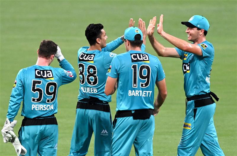 BRISBANE, AUSTRALIA - DECEMBER 30: Mujeeb Ur Rahman of the Heat celebrates taking the wicket of Ben McDermott of the Hurricanes during the Big Bash League match between the Hobart Hurricanes and Brisbane Heat at The Gabba, on December 30, 2020, in Brisbane, Australia. (Photo by Bradley Kanaris/Getty Images)