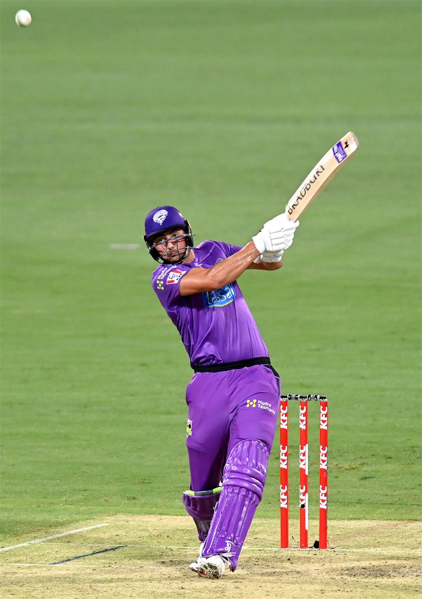 BRISBANE, AUSTRALIA - DECEMBER 30: Tim David of the Hurricanes hits the ball to the boundary for a four during the Big Bash League match between the Hobart Hurricanes and Brisbane Heat at The Gabba, on December 30, 2020, in Brisbane, Australia. (Photo by Bradley Kanaris/Getty Images)