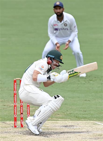 BRISBANE, AUSTRALIA - JANUARY 18: David Warner of Australia ducks a bouncer during day four of the 4th Test Match in the series between Australia and India at The Gabba on January 18, 2021 in Brisbane, Australia. (Photo by Bradley Kanaris/Getty Images)