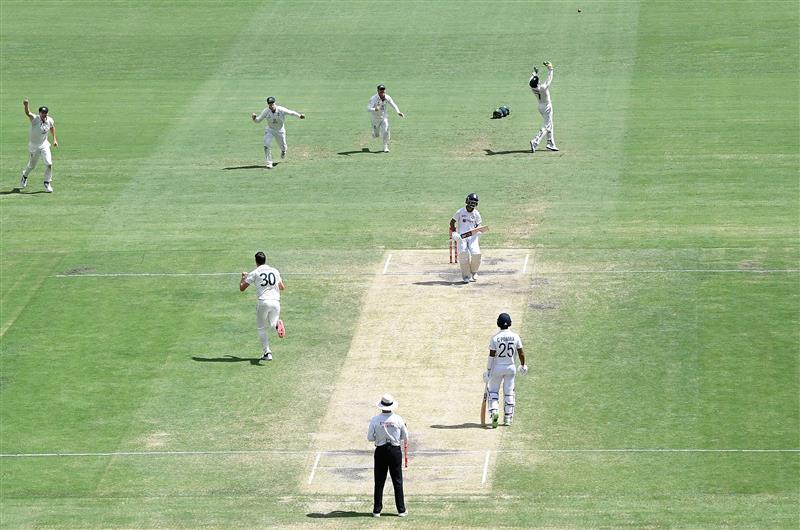 BRISBANE, AUSTRALIA - JANUARY 19: Pat Cummins of Australia celebrates taking the wicket of Ajinkya Rahane of India during day five of the 4th Test Match in the series between Australia and India at The Gabba on January 19, 2021 in Brisbane, Australia. (Photo by Bradley Kanaris/Getty Images)