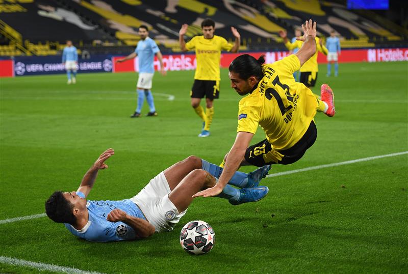 DORTMUND, GERMANY - APRIL 14: Rodrigo of Manchester City battles for possession with Emre Can of Borussia Dortmund during the UEFA Champions League Quarter Final Second Leg match between Borussia Dortmund and Manchester City at Signal Iduna Park on April 14, 2021 in Dortmund, Germany. Sporting stadiums around Germany remain under strict restrictions due to the Coronavirus Pandemic as Government social distancing laws prohibit fans inside venues resulting in games being played behind closed doors.  (Photo by Frederic Scheidemann/Getty Images)
