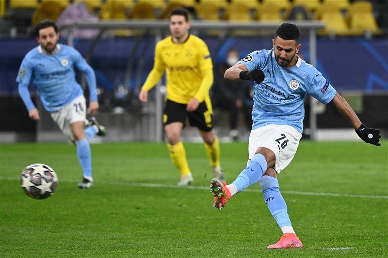 Manchester City's Algerian midfielder Riyad Mahrez scores the 1-1 goal from the penalty spot during the UEFA Champions League quarter-final second leg football match between BVB Borussia Dortmund and Manchester City in Dortmund, western Germany, on April 14, 2021. (Photo by Ina Fassbender / various sources / AFP) (Photo by INA FASSBENDER/AFP via Getty Images)