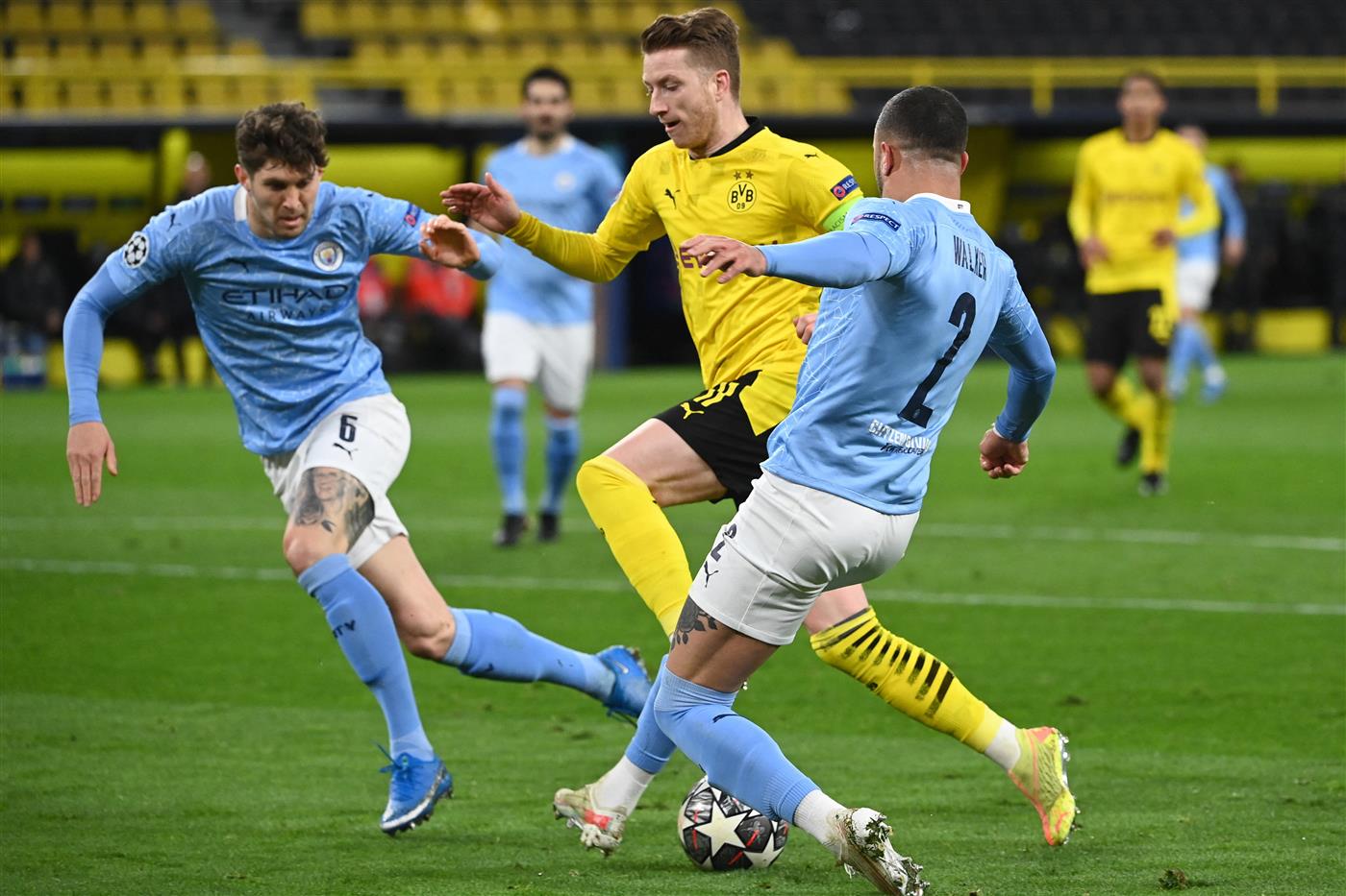 Dortmund's German forward Marco Reus (C) Manchester City's English defender John Stones (L) mand Manchester City's English defender Kyle Walker (R) vie for the ball during the UEFA Champions League quarter-final second leg football match between BVB Borussia Dortmund and Manchester City in Dortmund, western Germany, on April 14, 2021. (Photo by Ina Fassbender / various sources / AFP) (Photo by INA FASSBENDER/AFP via Getty Images)