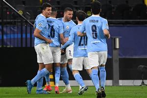 Manchester City's Algerian midfielder Riyad Mahrez (C) celebrates scoring the 1-1 goal from the penalty spot with his team-mates during the UEFA Champions League quarter-final second leg football match between BVB Borussia Dortmund and Manchester City in Dortmund, western Germany, on April 14, 2021. (Photo by Ina Fassbender / various sources / AFP) (Photo by INA FASSBENDER/AFP via Getty Images)