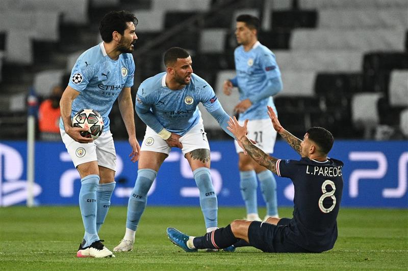Manchester City's English defender Kyle Walker (C) helps Paris Saint-Germain's Argentinian midfielder Leandro Paredes (R) during the UEFA Champions League first leg semi-final football match between Paris Saint-Germain (PSG) and Manchester City at the Parc des Princes stadium in Paris on April 28, 2021. (Getty Images)