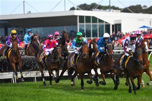 WARRNAMBOOL, AUSTRALIA - MAY 06: Clayton Douglas riding Gold Medals (ctr pink cap) jumping in the first lap before defeating Aaron Kuru riding Zed Em in Race 7, the Grand Annual Steeplechase, on Grand Annual Day during the Warrnambool Jumps Carnival at Warrnambool Racing Club on May 06, 2021 in Warrnambool, Australia. (Photo by Vince Caligiuri/Getty Images)