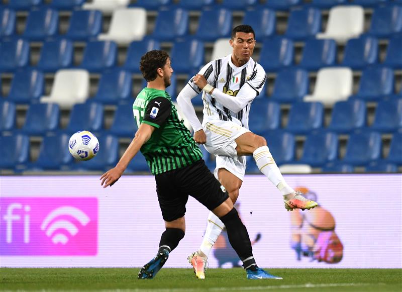 REGGIO NELL'EMILIA, ITALY - MAY 12: Cristiano Ronaldo of Juventus is challenged by Manuel Locatelli of U.S. Sassuolo Calcio during the Serie A match between US Sassuolo and Juventus at Mapei Stadium - Città del Tricolore on May 12, 2021 in Reggio nell'Emilia, Italy. Sporting stadiums around Italy remain under strict restrictions due to the Coronavirus Pandemic as Government social distancing laws prohibit fans inside venues resulting in games being played behind closed doors.  (Getty Images)