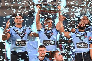 GOLD COAST, AUSTRALIA - JULY 14: James Tedesco of the Blues holds aloft the Origin trophy and celebrates with team mates after winning the series 2-1 after game three of the 2021 State of Origin Series between the New South Wales Blues and the Queensland Maroons at Cbus Super Stadium on July 14, 2021 in Gold Coast, Australia. (Photo by Bradley Kanaris/Getty Images)