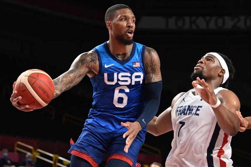 USA's Damian Lillard (L) tries to pass the past France's Guerschon Yabusele during the men's preliminary round group A basketball match between France and USA during the Tokyo 2020 Olympic Games at the Saitama Super Arena in Saitama on July 25, 2021. (Getty Images)