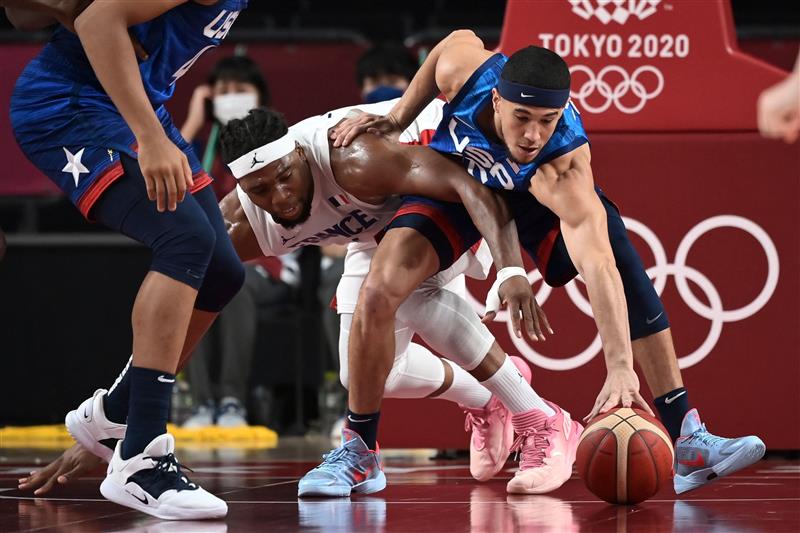 USA's Devin Booker (R) fights for the ball with France's Guerschon Yabusele during the men's preliminary round group A basketball match between France and USA during the Tokyo 2020 Olympic Games at the Saitama Super Arena in Saitama on July 25, 2021. (Getty Images)