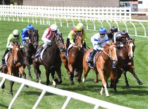 MELBOURNE, AUSTRALIA - OCTOBER 02: Damien Oliver riding  Kementari (back blue) before winning Race 4, the Gilgai Stakes during Melbourne Racing at Flemington Racecourse on October 02, 2021 in Melbourne, Australia. (Photo by Vince Caligiuri/Getty Images)
