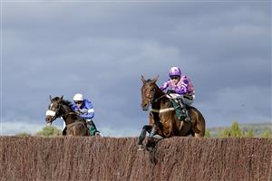 CHELTENHAM, ENGLAND - OCTOBER 22: Tom Cannon riding Annual Invictus (pink) clear the last to win The 888sport Novices' Limited Handicap Chase at Cheltenham Racecourse on October 22, 2021 in Cheltenham, England. (Photo by Alan Crowhurst/Getty Images)