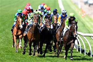 MELBOURNE, AUSTRALIA - NOVEMBER 02: The field pass the finish post for the first time in race 7, the Lexus Melbourne Cup during 2021 Melbourne Cup Day at Flemington Racecourse on November 02, 2021 in Melbourne, Australia. (Photo by Quinn Rooney/Getty Images)