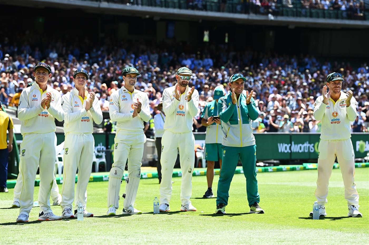 MELBOURNE, AUSTRALIA - DECEMBER 28: (L-R) Marnus Labuschagne, Steve Smith, Alex Carey, Nathan Lyon, Australia coach Justin Langer and David Warner are seen applauding teammate Scott Boland while he