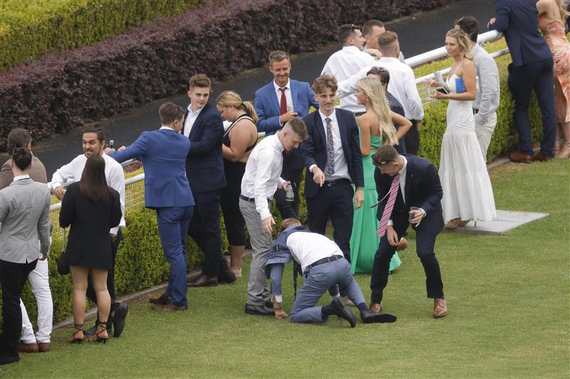 SYDNEY, AUSTRALIA - FEBRUARY 12: A man falls over as a rain shower hits during Sydney Racing at Royal Randwick Racecourse on February 12, 2022 in Sydney, Australia. (Photo by Jenny Evans/Getty Images)