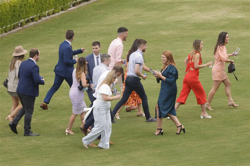 SYDNEY, AUSTRALIA - FEBRUARY 12: Racegoers take shelter from a rain shower during Sydney Racing at Royal Randwick Racecourse on February 12, 2022 in Sydney, Australia. (Photo by Jenny Evans/Getty Images)