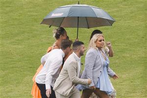 SYDNEY, AUSTRALIA - FEBRUARY 12: Racegoers take shelter from a rain shower during Sydney Racing at Royal Randwick Racecourse on February 12, 2022 in Sydney, Australia. (Photo by Jenny Evans/Getty Images)