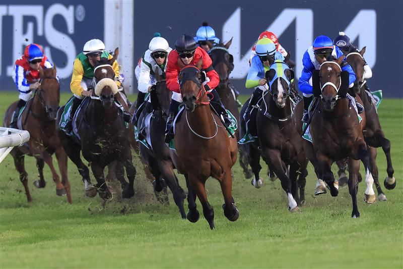 SYDNEY, AUSTRALIA - MARCH 12: Tyler Schiller on Taksu (red) leads the field at the home turn to win race 9 the Vale Alan Brown AM Handicap during Sydney Racing Chandon Ladies Day at Rosehill Gardens on March 12, 2022 in Sydney, Australia. (Photo by Mark Evans/Getty Images)