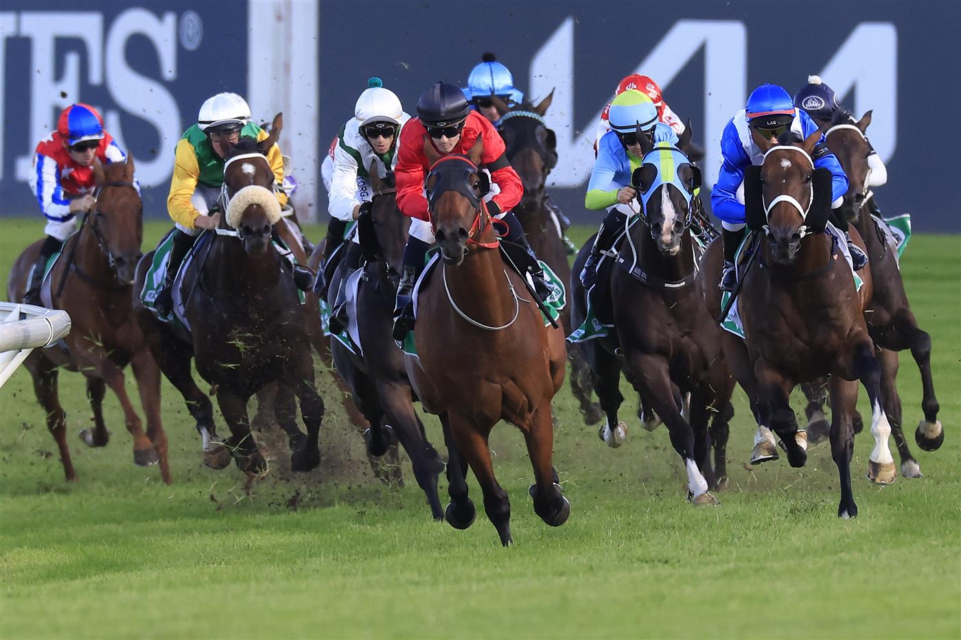 SYDNEY, AUSTRALIA - MARCH 12: Tyler Schiller on Taksu (red) leads the field at the home turn to win race 9 the Vale Alan Brown AM Handicap during Sydney Racing Chandon Ladies Day at Rosehill Gardens on March 12, 2022 in Sydney, Australia. (Photo by Mark Evans/Getty Images)