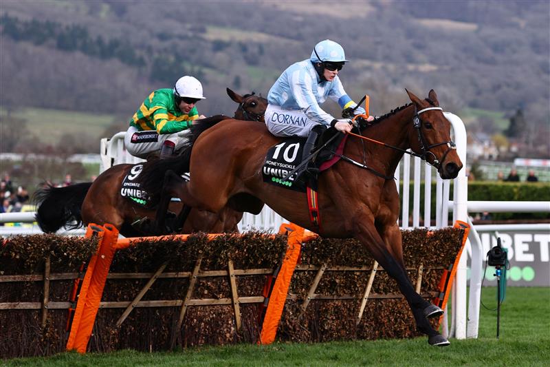 Jockey Rachael Blackmore rides Honeysuckle (R) to victory ahead of Aidan Coleman on Epatante (L) in the Champion Hurdle on the first day of the Cheltenham Festival at Cheltenham Racecourse, in Cheltenham, England on March 15, 2022. (Photo by Adrian DENNIS / AFP) (Photo by ADRIAN DENNIS/AFP via Getty Images)