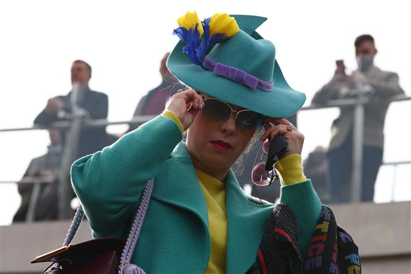 A racegoer adjusts her sunglasses on the first day of the Cheltenham Festival at Cheltenham Racecourse, in Cheltenham, England on March 15, 2022. (Photo by Adrian DENNIS / AFP) (Photo by ADRIAN DENNIS/AFP via Getty Images)