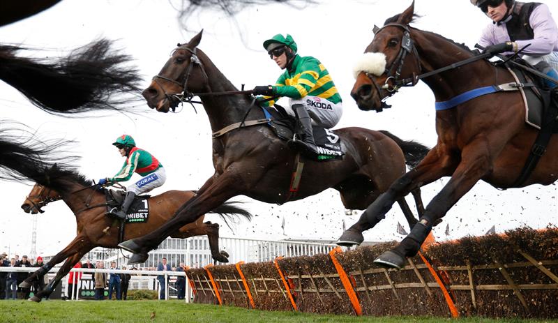 Jockey Tom Scudamore on Adagio (L) and jockey Mark Walsh on Saint Roi (C) jump a hurdle during the Champion Hurdle on the first day of the Cheltenham Festival at Cheltenham Racecourse, in Cheltenham, England on March 15, 2022. (Photo by Adrian DENNIS / AFP) (Photo by ADRIAN DENNIS/AFP via Getty Images)